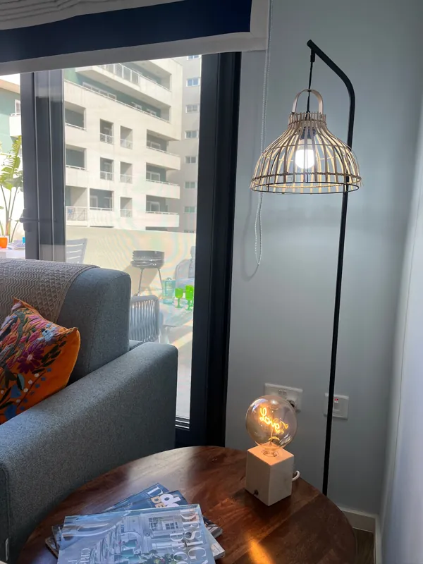 Reading corner with a rattan floor lamp beside the terrace doors