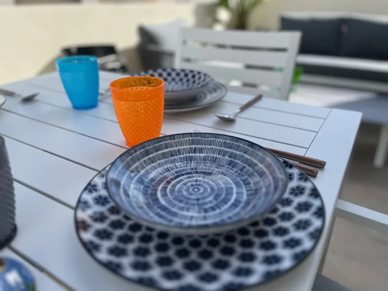 Blue and white patterned plates and coloured glasses on the terrace table